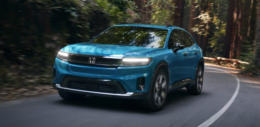 2024 Honda Prologue Elite front view driving on a road in a forest.
