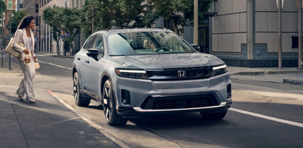 2024 Honda Prologue Elite parked in a city street with person walking up to door.