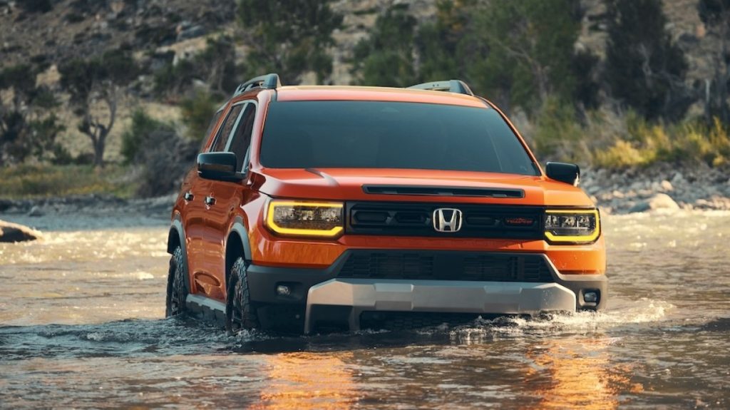 Front view of a 2026 Honda Passport Trailsport driving through water.