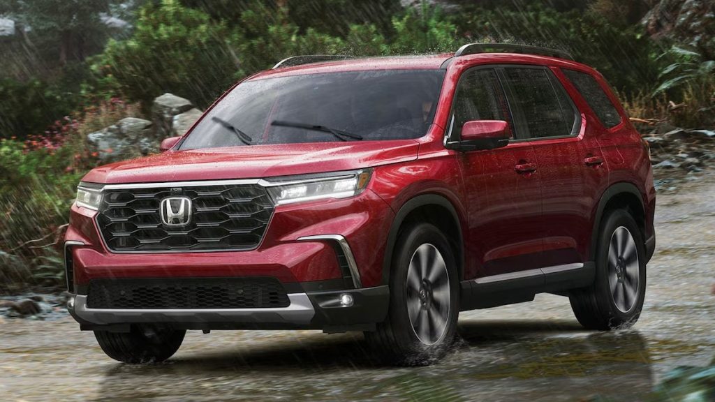 Red 2025 Honda Pilot driving in the rain off road