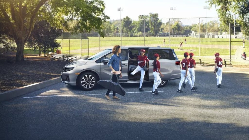 2026 Honda Odyssey parked at a park with a youth baseball team getting out of the minivan.